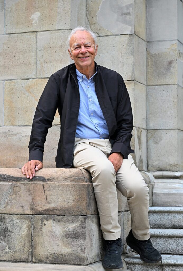 Peter Singer seated on stone steps